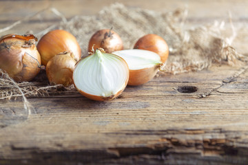 Zwiebeln auf Jute Unterlage auf einem Holztisch.