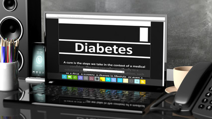 Laptop with Diabetes information on screen, on desktop with office objects.