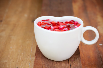 red rose and ceramic heart shape on old wooden