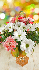 Obraz na płótnie Canvas flowers and gift box on a wooden table closeup