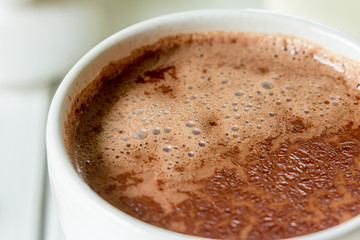 Hot Chocolate in White Beautiful Cup on Light White Wooden Background, Close-up, Horizontal