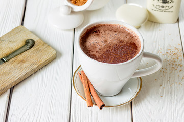 Hot Chocolate with Cinnamon on Light Wooden Background