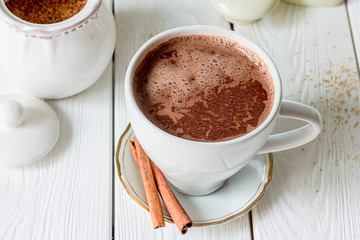 Hot Chocolate with Cinnamon on White Wooden Background, Top View