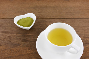 The cup of Japanese green tea on wooden planks.