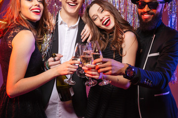 Group of cheerful young friends drinking champagne together