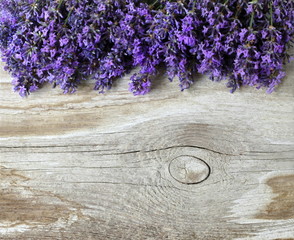 Fresh lavender flowers on a wooden background. Decorative border or frame with lavander and old...