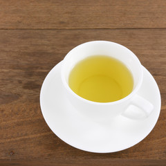 The cup of Japanese green tea on wooden planks.