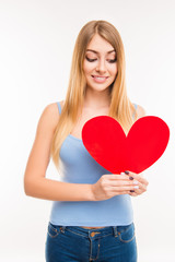 Pretty young  girl looking at big paper heart