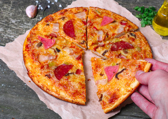 close-up Delicious Meat Pizza with Ham, Bacon and sausages on the wooden background