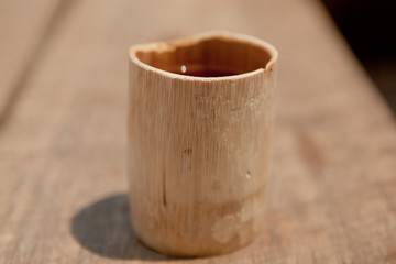 Bamboo drinking cup on a piece of wood