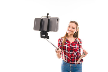 Happy young pretty girl making photo with selfie stick