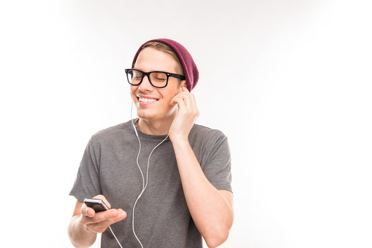 Portrait of a happy man with glasses and hat litening to music