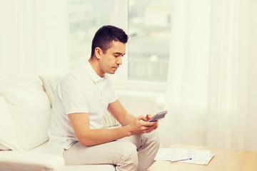 man with papers and calculator at home