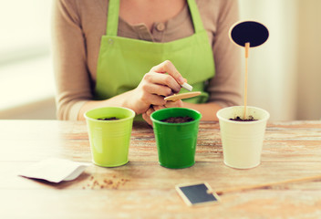 close up of woman writing name on garden sign