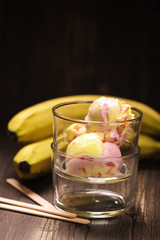 Homemade banana strawberry ice-cream in glasses over wooden background. Toned image. Selective focus