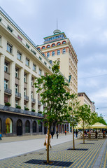 Unrecognizable pedestrians walk along central Slovenska Street in front of Hotel Slon and Central Post. Ljubljana is the biggest city and capital of Slovenia.