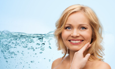 smiling woman with bare shoulders touching face