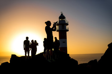 Fototapeta premium Silhouettes of people near the lighthouse