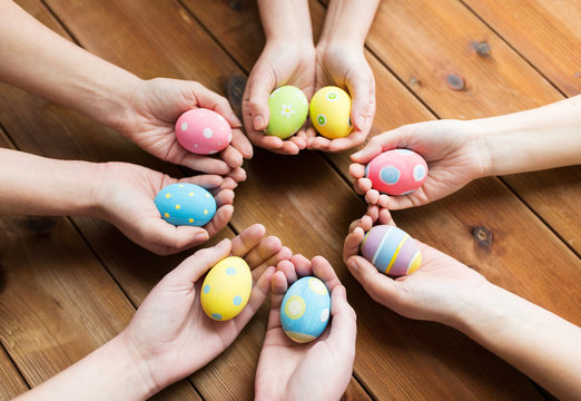 close up of woman hands with colored easter eggs