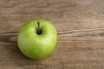 Green apple on wooden background
