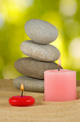 image of candles and stones on sand closeup