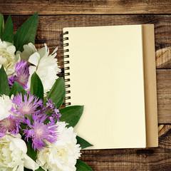 Peony and wild flowers bouquet with notepad
