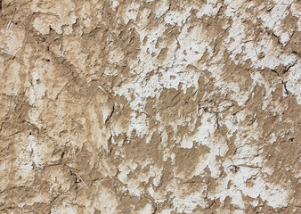 texture of grey adobe wall with pieces of straw