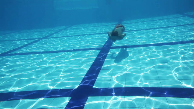 Young Boy Swimming Underwater in a Pool
