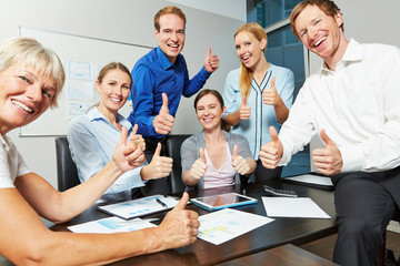 Business Team hält Daumen hoch im Büro