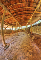 Ruins of an ancient fortress covered with wooden roof in fish-eye perspective