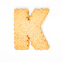 letter K made of cracker cookie isolated on white background.