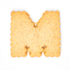 letter M made of cracker cookie isolated on white background.