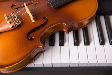 Fototapeta premium Violin on the piano on a black background