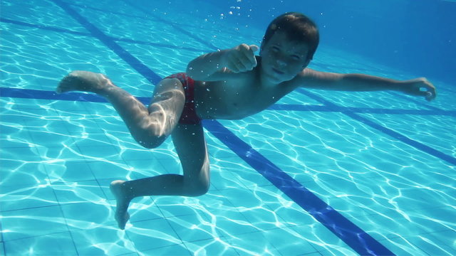 Young Boy Having Fun Underwater in a Pool