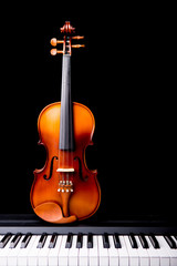 Violin on the piano on a black background © ittipol