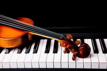 Violin on the piano on a black background © ittipol
