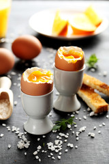 Boiled egg with toasts on a black wooden table