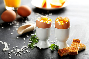 Boiled egg with toasts on a black wooden table