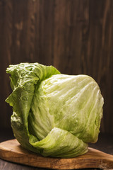 Head of fresh organic iceberg lettuce over vintage wooden background. Selective focus. Toned image © happy_lark