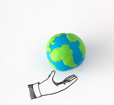 Ecology concept with modelling clay of earth globe on drawing of hand on white background.