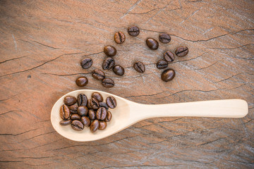 close up of Coffee beans with wooden spoon on grunge wooden background