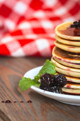 stack of pancakes  white plate  cherry jam, mint leaves, red nap