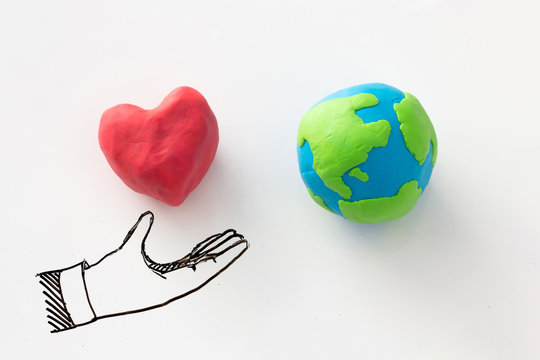 Love the world concept , heart in hand reach to the world