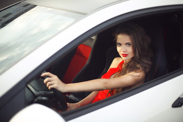 Beautiful smiling girl driver driving in car, sensual brunette m