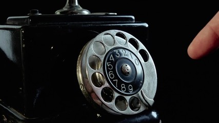 Old vintage telephone. 
Closeup on finger plate. Person is dialing a number. Sound included.