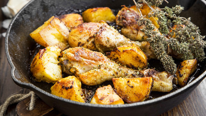 Roasted chicken legs with herbs and baked potatoes granish