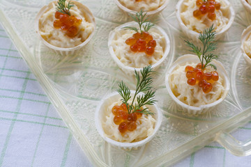 Tartlets with cream cheese and red caviar close up. Snacks with red caviar with aperitif. Light background.