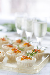 Tartlets with cream cheese and red caviar close up. Snacks with red caviar with aperitif. Light background.