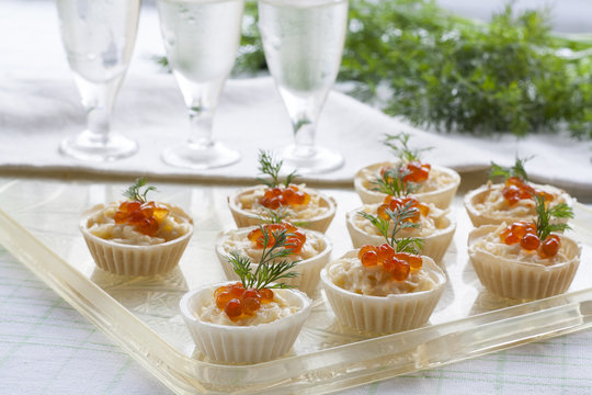 Tartlets with cream cheese and red caviar close up. Snacks with red caviar with aperitif. Light background.