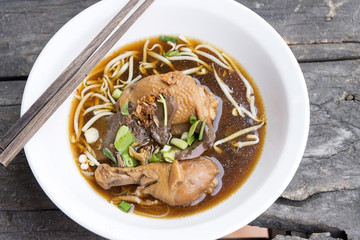 top view of the Thai style chicken noodles on the retro wooden table